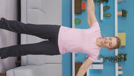 Vertical-video-of-Woman-exercising-at-home-stretching-her-arms.-Healthy-life-fitness.